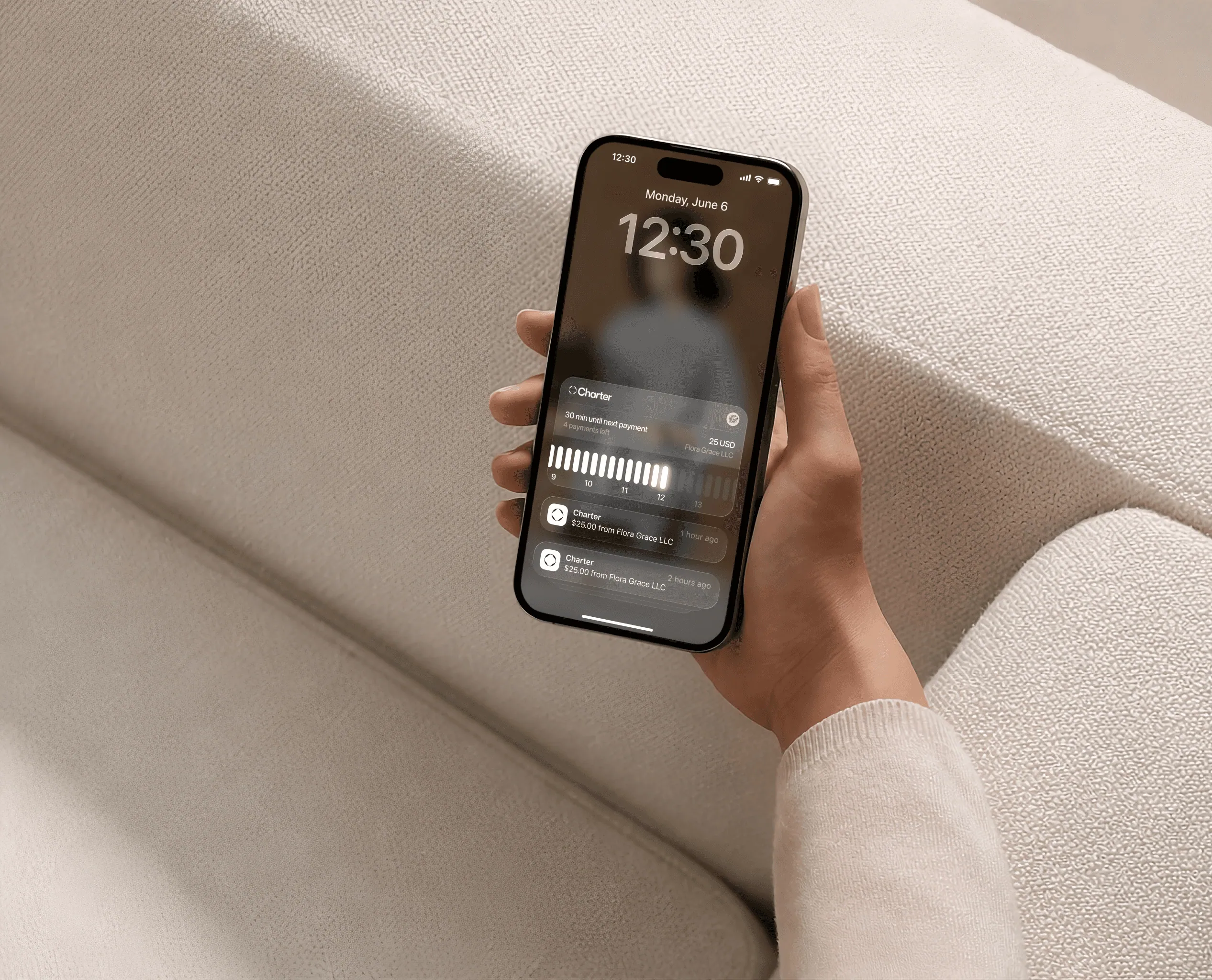 A hand holding a phone with Charter payment notifications on its lock screen